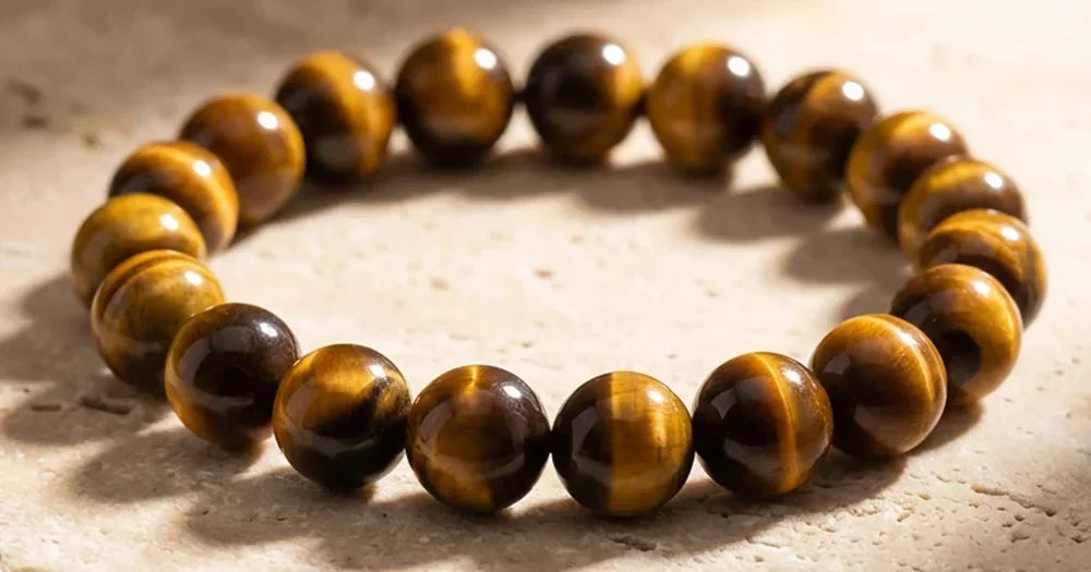 Bracelet en Œil de Tigre posé sur une pierre beige